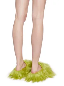 Gros plan sur des chaussons en fausse fourrure vert citron portés par un mannequin