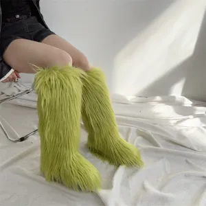 Macro view of fluffy bright green faux fur knee-high snow boots with shaggy texture