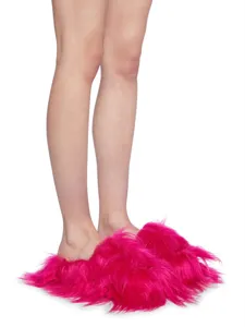 Gros plan de pantoufles en fausse fourrure rose vif portées dans un style punk Y2K