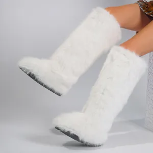 Close-up view of fluffy white faux fox fur knee-high snow boots for winter Y2K fashion