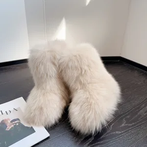 Nahaufnahme der dicken, flauschigen Textur dieser cremefarbenen Y2K-Kunstfell-Schneestiefel.