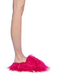 Détail de chaussons en fausse fourrure rose vif, style punk Y2K avec poils longs.
