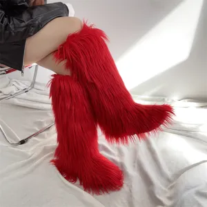 Detailed view of red long faux fur knee-high boots with fluffy texture