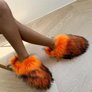 Detailansicht der stylischen flachen Hausschuhe aus orange-schwarzem Pelzimitat