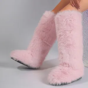 Close-up of pink faux fur knee-high boots with fluffy texture and thick sole detail.