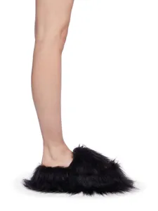 Détail latéral de chaussons en fausse fourrure noire style punk y2k à poils longs