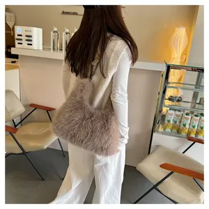 Model carrying a soft brown faux fur tote bag in a cozy cafe setting for winter style