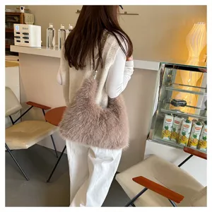 Detailed view of a cozy dusty pink faux fur tote bag styled in a trendy cafe interior
