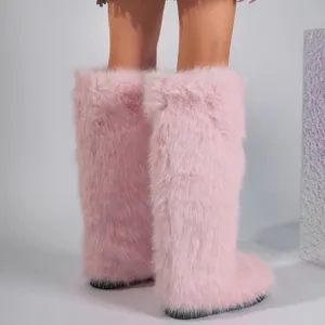 Close-up of fluffy pink faux fur knee-high snow boots for women in trendy Y2K style