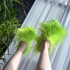 Gros plan de chaussons duveteux vert fluo avec de longs poils en fausse fourrure Y2K.