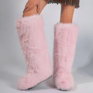 Close-up view of stylish pink faux fur knee-high boots with plush warm texture in Y2K style