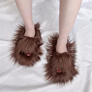 Gros plan sur des chaussons en fausse fourrure marron à poils longs sur tissu blanc