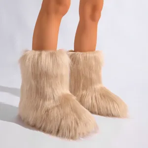 Gros plan sur des bottes de neige en fausse fourrure beige au style Y2K avec une texture très douce