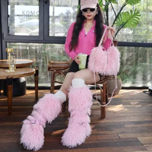Modella che indossa stivali da neve in pelliccia rosa e borsa coordinata in un bar caffè