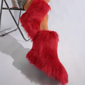 Gros plan de bottes de neige en fausse fourrure rouge style Y2K sur mannequin