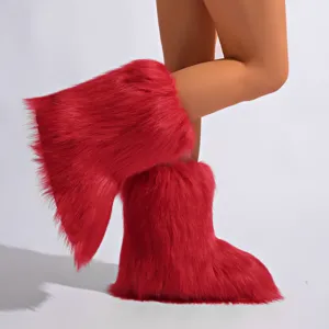 Détail en gros plan de bottes de neige surdimensionnées en fausse fourrure rouge style Y2K