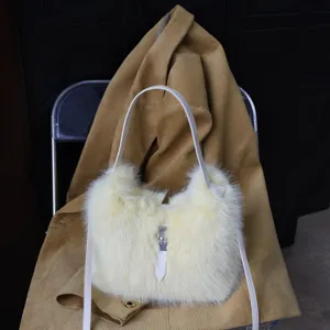 Detailansicht einer weichen, cremefarbenen Kunstpelztasche vor einer Cordjacke.