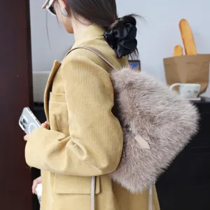 Detail einer flauschigen Kunstpelz-Schultertasche mit Lederriemen an einer Kordjacke