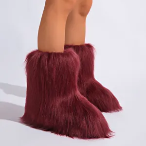 Gros plan de bottes de neige bordeaux en fausse fourrure au style Y2K duveteux et chaud