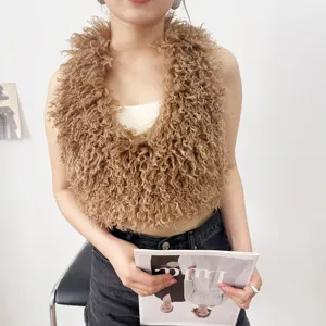 Dettaglio del gilet in finta pelliccia riccia marrone con trama molto voluminosa.