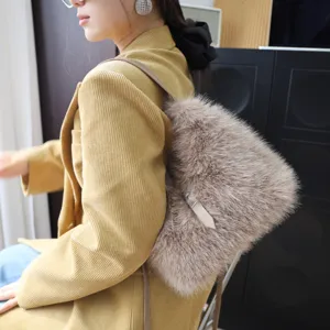 Asiatisches Model mit einer flauschigen Kunstfell-Umhängetasche in Beige und Cordjacke