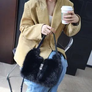 Elegante schwarze Kunstpelz-Handtasche mit Metalldrehverschluss, gehalten vom Modell.