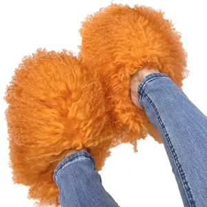 Bright orange fluffy Mongolian fur slides slippers shown being worn with blue jeans