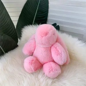 Gros plan d'un lapin en peluche rose assis sur un fond de fausse fourrure blanche