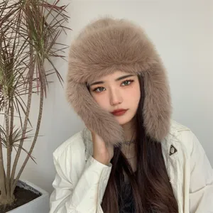Detailed view of a fluffy beige faux fur ushanka hat with protective ear flaps for winter.