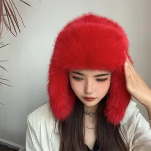 Close-up of vibrant red faux fox fur trapper hat with fluffy texture for winter warmth