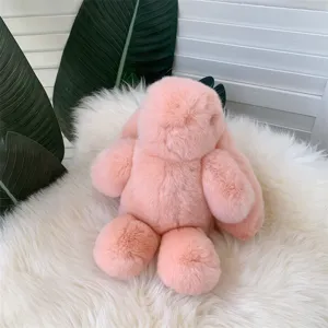 Vue détaillée d'un lapin en peluche rose avec une texture de fourrure douce sur un tapis.