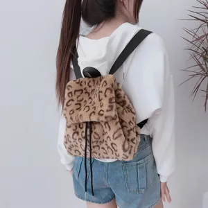 Detail eines plüschigen Rucksacks mit Leopardenmuster und Kordelzug über einem Hoodie