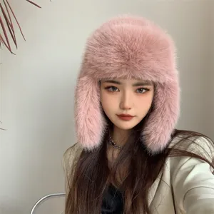 Detailed view of soft pink faux fox fur trapper hat with warm ear flaps worn by a model