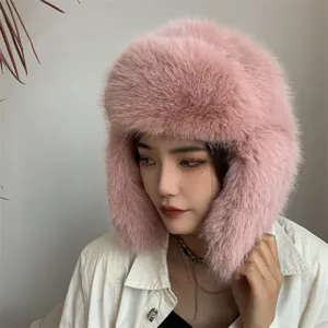 Close-up view of a pink faux fox fur ushanka hat featuring plush ear flaps for winter