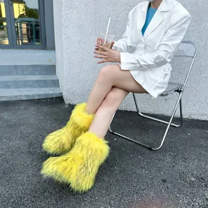 Vibrant yellow fluffy faux fur snow boots worn by a model in a trendy Y2K fashion style