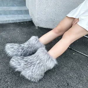 Close-up of fluffy grey faux raccoon fur snow boots in a trendy and warm Y2K style