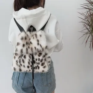 Rückansicht eines Plüsch-Rucksacks mit Leopardenmuster und Kordelzug über weißem Hoodie