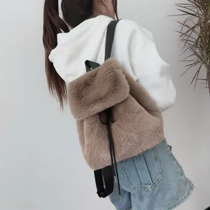 Rückansicht eines weichen braunen Plüschrucksacks aus Kunstfell mit Kordelzug am Modell.