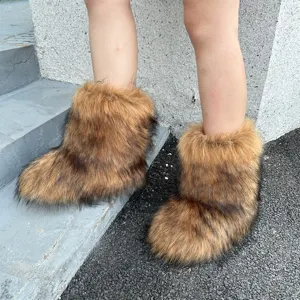 Detailed view of fluffy brown faux raccoon fur snow boots in Y2K style worn on legs