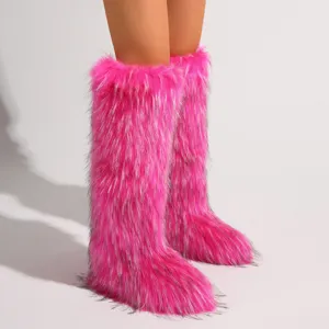 Nahaufnahme der leuchtend rosa Kniehohen Schneestiefel aus Kunstpelz im Y2K-Stil.
