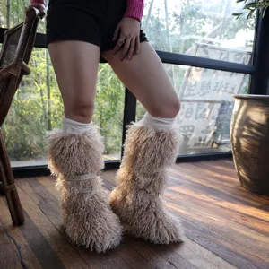 Stivali da neve in pelliccia beige con cinturini borchiati in un caldo ambiente lifestyle