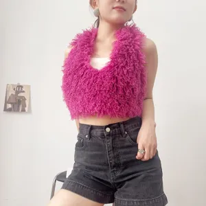 Dettaglio ravvicinato di un gilet all'americana in ecopelliccia riccia rosa vivace