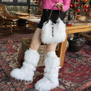 Dettaglio di stivali da neve bianchi in pelliccia e borsa di peluche coordinata con borchie.