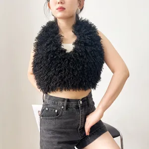 Dettaglio texture di gilet in finta pelliccia di agnello tibetano nero su modella