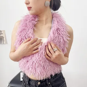 Dettaglio ravvicinato di un gilet all'americana in ecopelliccia rosa riccia con lana soffice