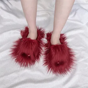 Vue rapprochée de claquettes rouges en fausse fourrure à poils longs de style y2k