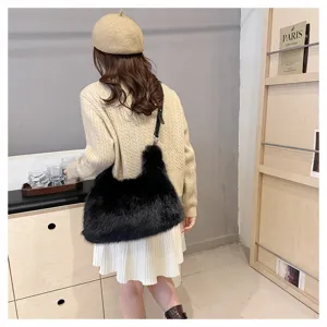 Chic black faux fox fur tote bag shown on model in a stylish cozy winter outfit styling