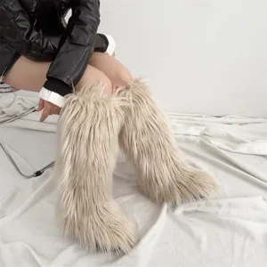 Close-up of stylish beige faux fur knee-high snow boots featuring long plush texture