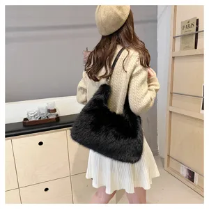 Model wearing a black faux fur hobo bag with a stylish pleated skirt outfit