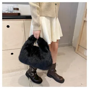 Close-up of black faux fur plush handbag held by model in stylish autumn outfit